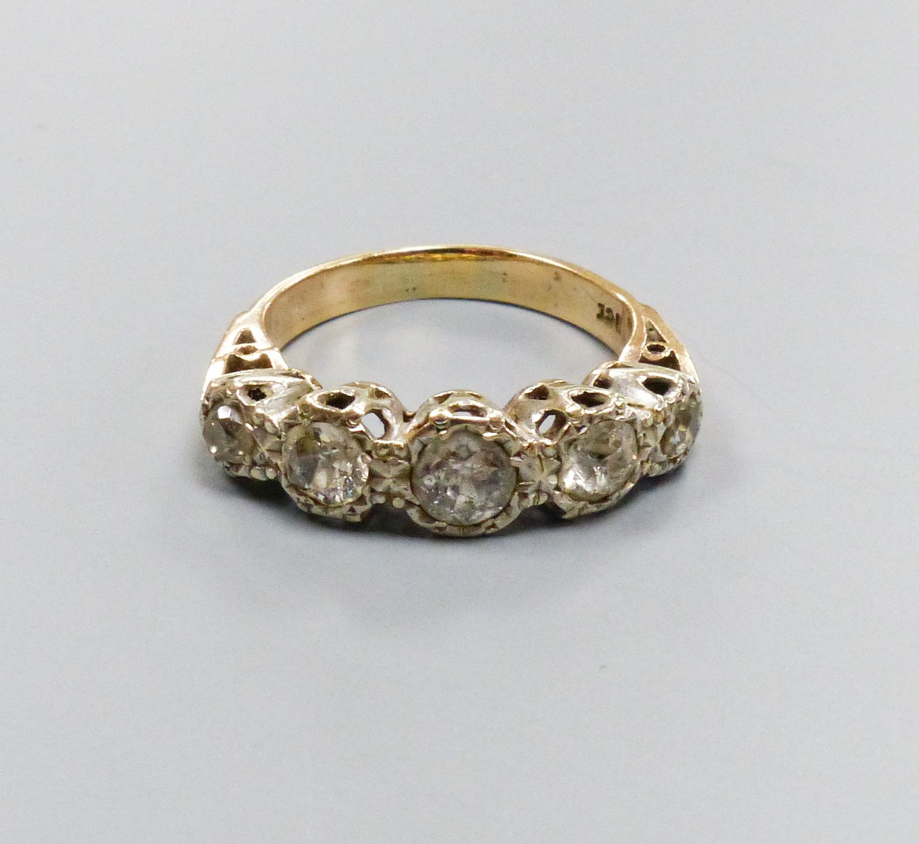 A five-stone diamond ring, 9ct white and yellow gold setting, claw-set with carved shoulders, size M, gross weight 4.3 grams.